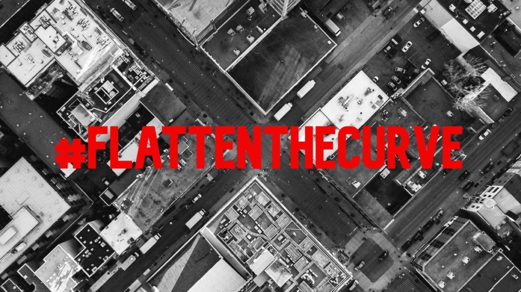 Black and white photo of a city from above, with relatively empty streets.  The text, in red, block letters, reads "#flattenthecurve".  This is an example of the project my students are working on from home -- they are making posters inspired by the work of Barbara Kruger to inform others about coronavirus facts and to combat myths about the virus.